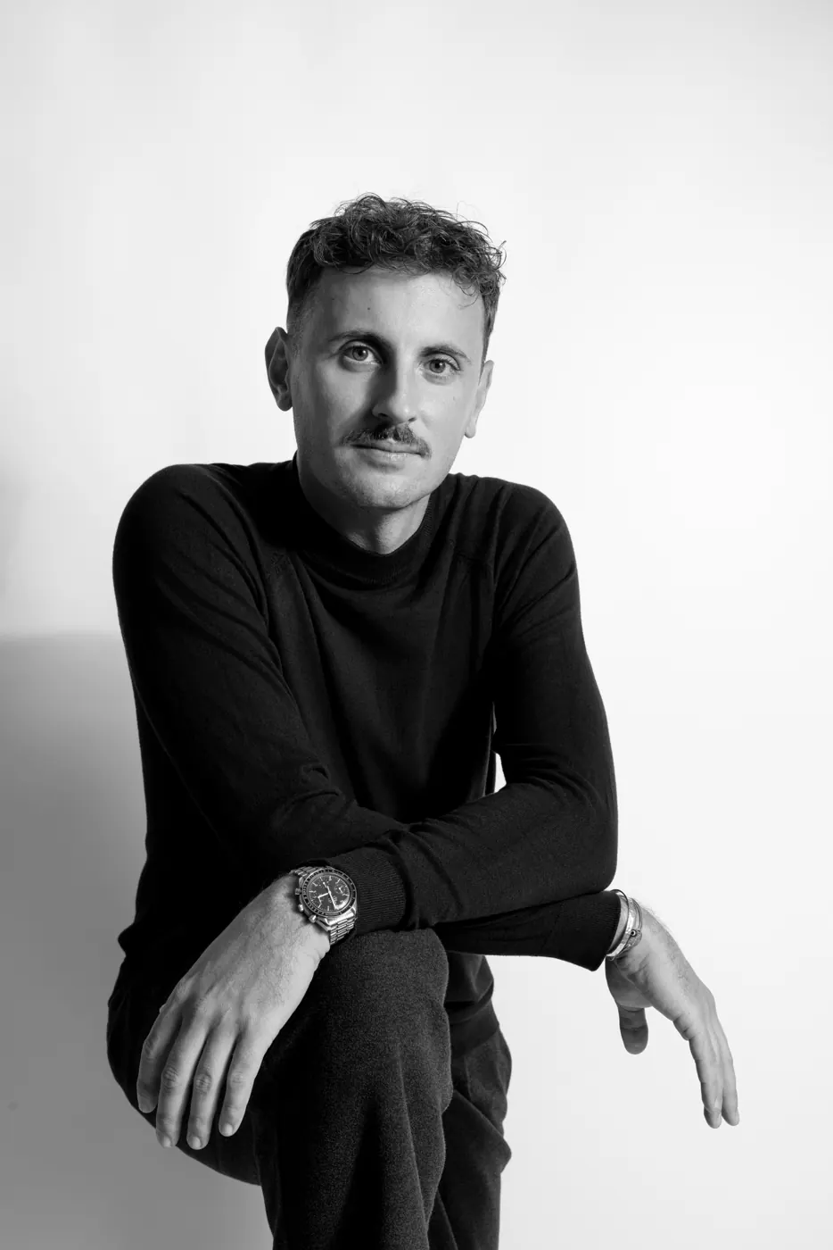 Portrait professionnel en noir et blanc de Roman Blum, assis, pull noir, sur fond clair, exemple de photo corporate